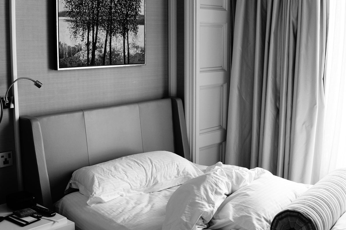 Chambre en noir et blanc, tableau d'arbres au-dessus du lit